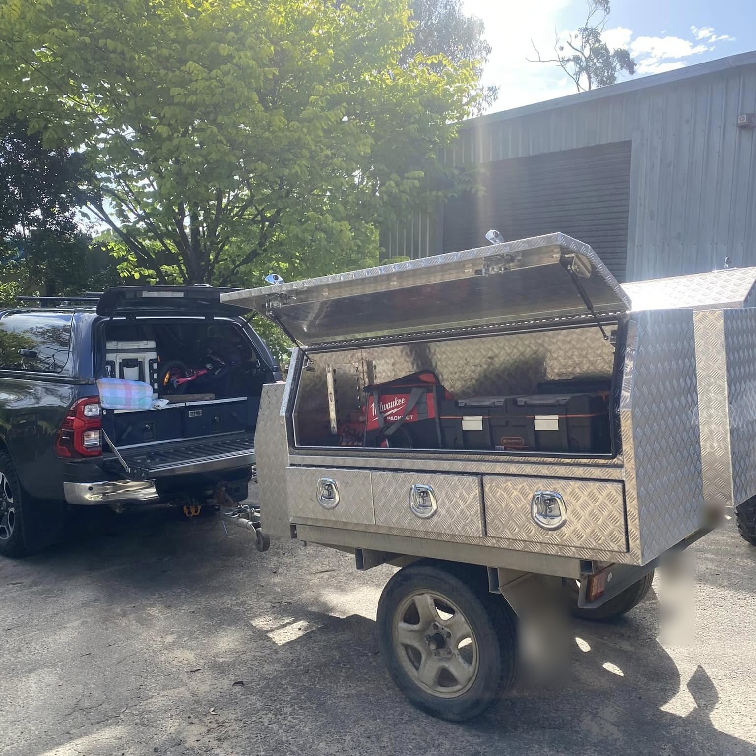 Marco's ute with the aluminium toolbox trailer hitched on, lid up and tool cases packed inside
